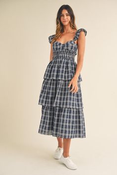 This navy midi dress has a sweetheart neckline and playful ruffle sleeves. The tiered ruffle bottom adds a touch of fun and femininity. Take your fashion game to the next level with the Lara Plaid Sweetheart Ruffled Midi Dress. Flirty Tiered Midi Dress For Brunch, Casual Midi Length Tiered Ruffle Dress, Casual Tiered Ruffle Midi Dress, Casual Tiered Midi Dress With Ruffles, Flirty Tiered Midi Dress With Ruffled Skirt, Chic Navy Midi Dress With Ruffles, Navy Ruffle Dress For Summer, Tiered Midi Dress With Ruffles For Brunch, Navy Ruffled Midi Dress