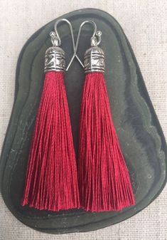 Chic dark red tassel earrings!  They would add a pop of color to any outfit for any occasion.  Dress them up or down.  They are timeless and versatile.  They are lightweight, fun and unique!The tassels measure 2 1/8” long by 1/4” wide.  They hang from simple silver ear wire hooks.  Overall drop length is about 2 1/4”.  Metal is allergy free plated silver.These are my latest creation!  I have them available in many colors!  Find them all under the category tassel earrings in my shop.Thanks for st Red Yarn Earrings, Red Tasseled Jewelry As A Gift, Red Tasseled Jewelry For Gift, Red Tassel Earrings For Gift, Red Dangle Tassel Earrings As Gift, Red Dangle Tassel Earrings For Gift, Red Bohemian Tassel Earrings As Gift, Red Tassel Drop Earrings Gift, Red Tassel Earrings With Latkans For Gifts