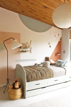 there is a bed in the room with two lamps above it and a teddy bear on top