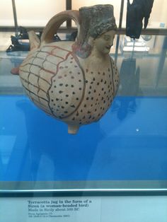 an ancient vase is on display in a glass case with blue water and other artifacts