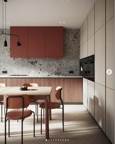 a modern kitchen with red cabinets and marble counter tops, along with a dining table