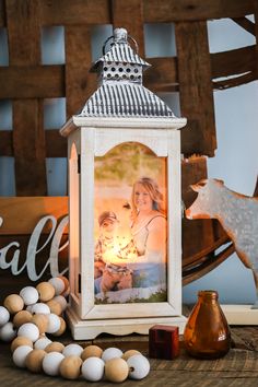 a white lantern sitting on top of a wooden table next to eggs and other decorations