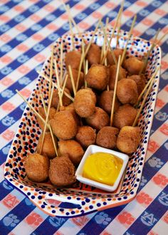 some food is sitting in a bowl with toothpicks and mustard on the side