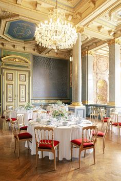 an elegant dining room with chandelier and tables set up for formal dinner or party