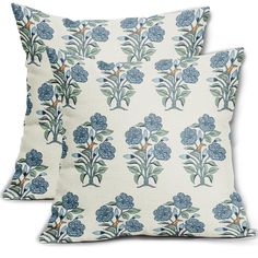 two pillows with blue flowers on them, one is white and the other is green