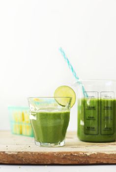 two glasses filled with green smoothie next to each other