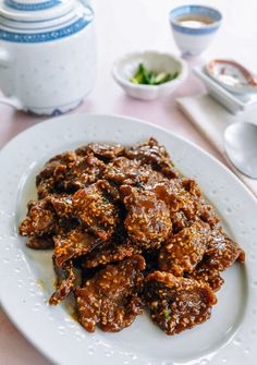 a white plate topped with meat covered in sauce