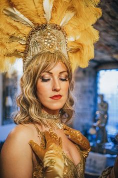 This is a hand crafted gold showgirl headdress, made to order. This design is made with gold ostrich feathers and a gold beaded trim along the hairline which falls beautifully. The headdress is finished with gold rhinestone artwork centred within the middle of the piece.  Please note that fabrics are subject to availability and may differ slightly to the photograph. We will try our best to maintain the closest possible matching fabrics and trims. Cheapest Gold Dress Up Long Wig Uk, Gold Gatsby Style Flapper Dress, Gold Costume Hats And Headpieces For Carnival, Gold Mardi Gras Costume Hats And Headpieces, Gold Fitted Flapper Dress For Costume Party, Gold Tall Crown Costume Hats And Headpieces, Fitted Gold Costume Hat For Carnival, Fitted Gold Carnival Costume Hat, Gold Headpieces For Costume Party And Carnival