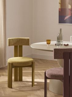 a dining room table with two chairs and a wine bottle on the table next to it