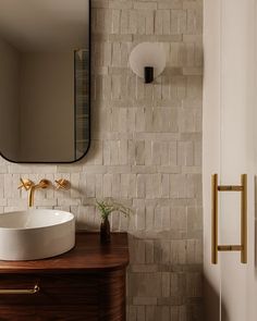 a bathroom sink sitting under a mirror on top of a wooden counter next to a door