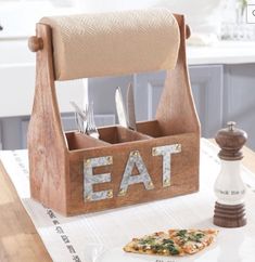 a wooden utensil holder with the word eat on it