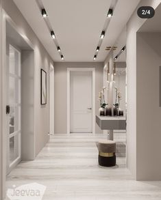 a long hallway with white walls and lights on either side of the hall, leading to another room