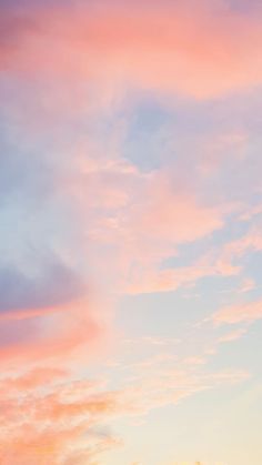 an airplane is flying in the sky with pink and blue clouds behind it at sunset