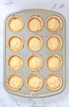 an uncooked muffin tin filled with mini pies