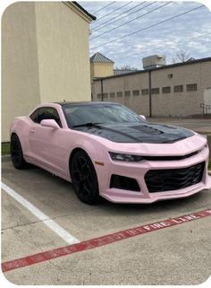 a pink chevrolet camaro parked in a parking lot