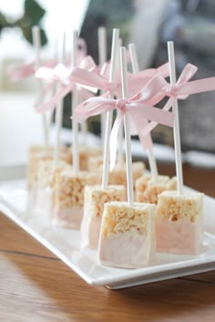 small marshmallows with pink bows are on a white plate