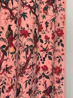 a pink curtain with birds and flowers on it