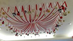 the ceiling is decorated with red and white ribbons, christmas ornaments, and star decorations