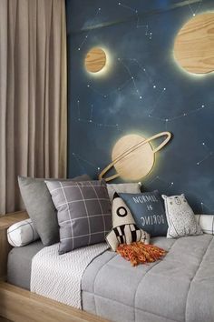 this is a bedroom with a space theme painted on the wall and bed in front of it