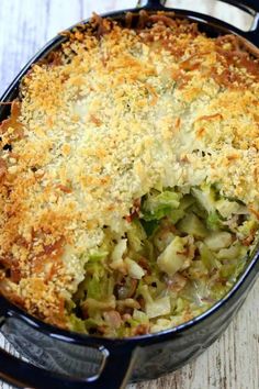 a casserole dish with cheese and vegetables in it on a wooden table top