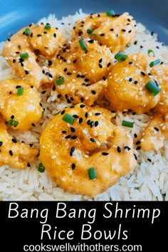 a blue bowl filled with rice covered in sesame seeds and topped with fried shrimp on top