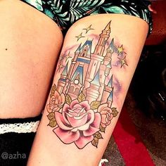 a woman's thigh with a tattoo of a castle and rose on her leg