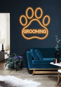 a living room with a blue couch and a neon sign that says grooming