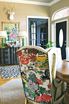 a dining room table and chairs with an antelope head on the wall