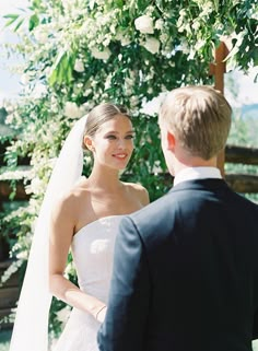 the bride and groom are looking at each other