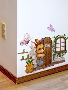 a painted wall with an image of a rabbit in front of a door and flowers