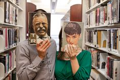 a man and woman standing next to each other holding up books in front of them