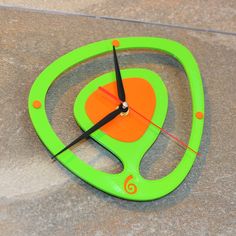 a green and orange clock sitting on the ground