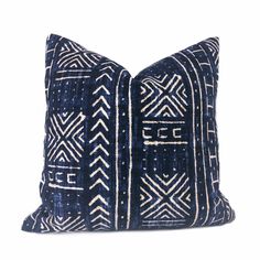 a black and white pillow with geometric designs on the front, sitting against a white background