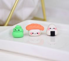 three small plastic toys sitting on top of a white tray