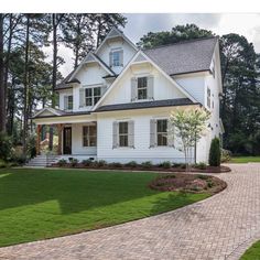 a large white house sitting on top of a lush green field