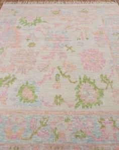 an old rug with flowers and leaves on it in the middle of a wooden floor