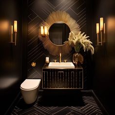 a black and gold bathroom with a toilet, sink, mirror and lights on the wall