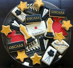 an oscars themed cookie is on a plate with stars and other decorations around it