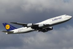 an airplane is flying in the sky on a cloudy day with blue and white colors