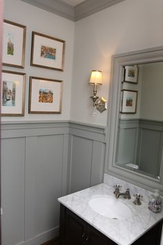 a white sink sitting under a bathroom mirror