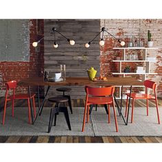 an image of a dining room setting with orange chairs and wooden table in the foreground