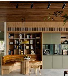 a room with a table, chairs and bookshelves on the shelves in it