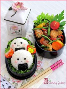 two bowls filled with rice and vegetables on top of a table next to chopsticks