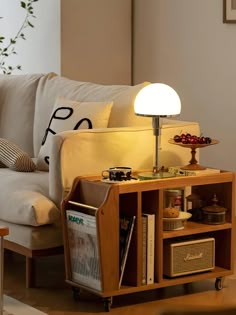 a living room with a couch, table lamp and bookshelf in the corner