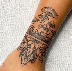 a tattoo on the foot of a woman with mushrooms