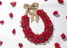 a wreath made out of red roses with a bow