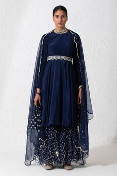 Midnight blue short anarkali with a round neckline, full length sleeves and cutout at the back. Comes with sequin embroidered gharara, scallop border dupatta and an embroidered belt.
Components: 4
Pattern: Embroidered
Type Of Work: Zardozi and Sequin
Neckline: Round
Sleeve Type: Long
Fabric: Crepe, Organza and Net
Color: Blue
Other Details: 
Dupatta with embroidered scallop border
Zardozi embroidered belt with scallop border
Cutout at the back
Note: The potli bag carried and choker worn by the m Short Anarkali, Scallop Border, Potli Bag, Embroidered Belt, Fashion App, Set For Women, Blue Shorts, Anarkali, Aza Fashion