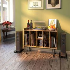 an entertainment center with speakers, bookshelf and pictures on the wall