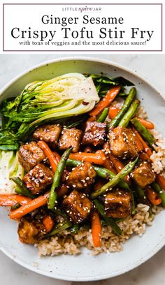 a white plate topped with meat and veggies covered in sauce next to rice