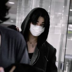 a woman wearing a face mask walking through an airport